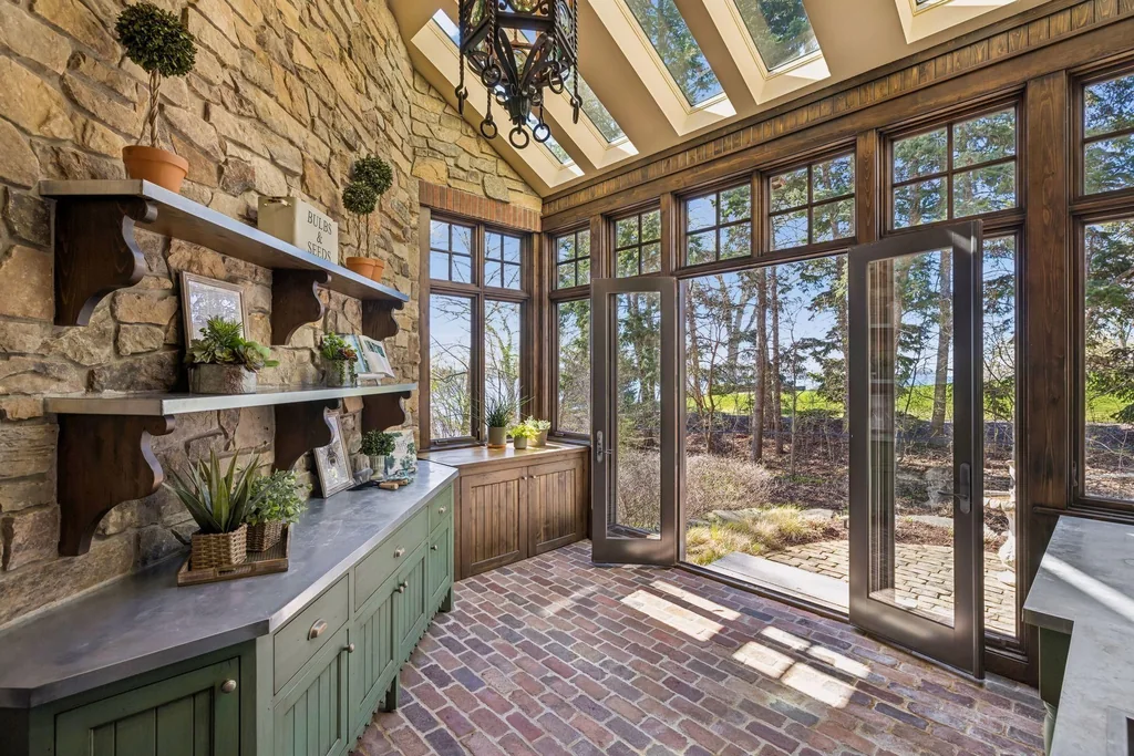 Wayzata Bay Estate With an Octagonal Great Room and 216 Feet of Shoreline Asks $16,450,000 11 A glazed conservatory pairs a stone fireplace with views toward the garden at 358 Ferndale Rd S, Wayzata
