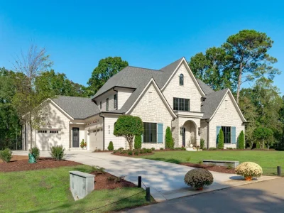Raleigh’s Magnificent Stonewood Estate With a Lavish Heated Poolside Lounge Lists for $3,025,000 1 The stone-detailed front elevation combines steep gables with dark window frames at 6744 Brixley Crest Ct, Raleigh.