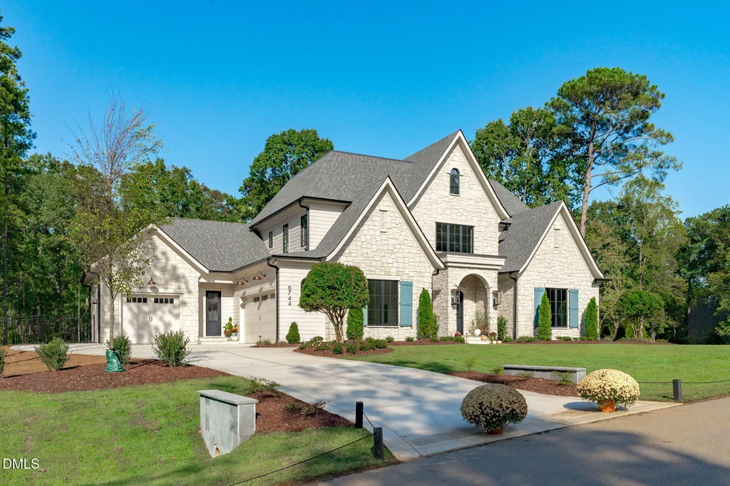 European Inspired Front Exterior | 6744 Brixley Crest Ct The stone-detailed front elevation combines steep gables with dark window frames at 6744 Brixley Crest Ct, Raleigh.