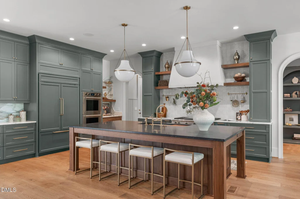 Kitchen Quartz Island | 6744 Brixley Crest Ct An expansive quartz island combines seating with a warm wood base at 6744 Brixley Crest Ct, Raleigh.