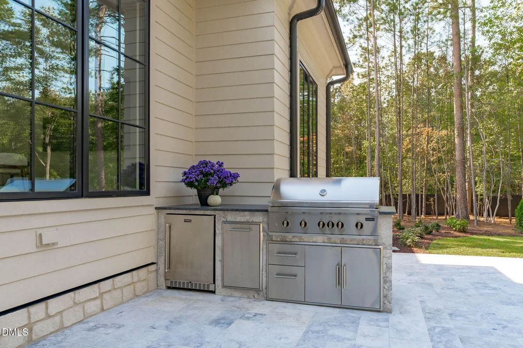 Outdoor Kitchen Grill | 6744 Brixley Crest Ct An outdoor kitchen supports entertaining beside the covered lounge at 6744 Brixley Crest Ct, Raleigh.