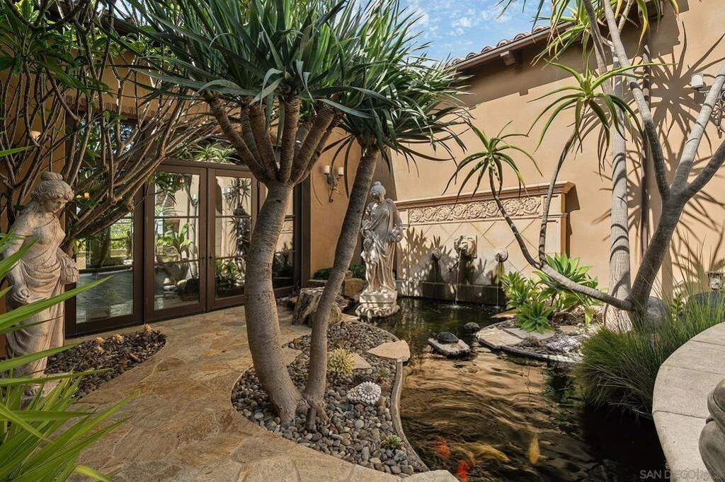8619 Via Rancho Cielo – Courtyard Water Feature 8619 Via Rancho Cielo, Rancho Santa Fe: a courtyard water feature is surrounded by stonework and greenery.