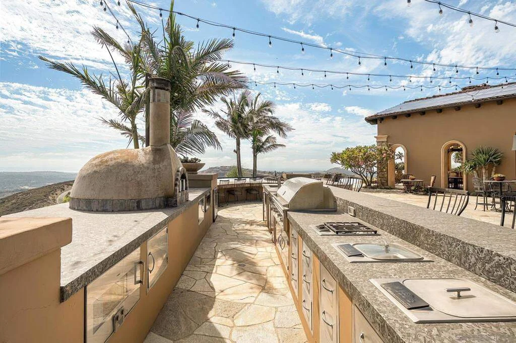8619 Via Rancho Cielo – Outdoor Kitchen 8619 Via Rancho Cielo, Rancho Santa Fe: the outdoor kitchen includes a pizza oven and an extended cooking counter.