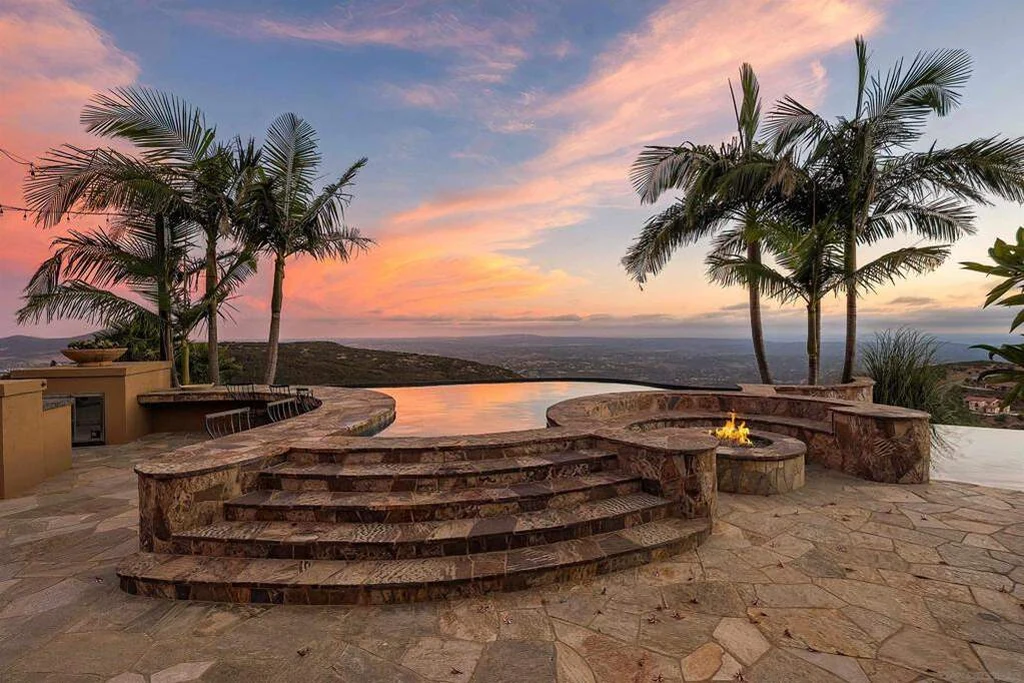 8619 Via Rancho Cielo – Sunset Pool Terrace 8619 Via Rancho Cielo, Rancho Santa Fe: the curved pool terrace faces a vivid sunset beyond the palms.